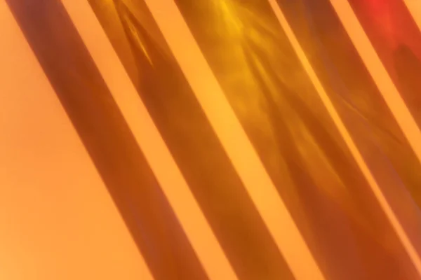 Different cosmetic glass bottles standing on orange beige background. Abstract pattern