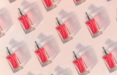 Pattern of Transparent perfume bottle lying on pink background