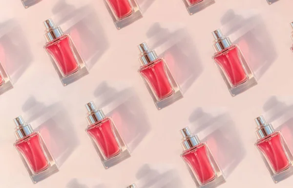 Modèle de flacon de parfum transparent couché sur fond rose — Photo