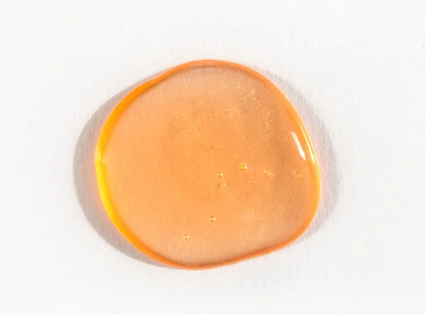 Orange cosmetics gel or slime drop on white background — Stock fotografie
