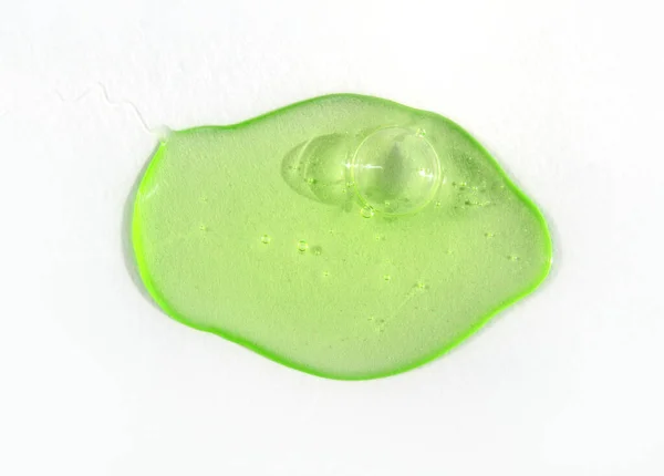 Drop of green fluid hyaluronic acid on white background. Cosmetics and healthcare concept closeup — Stock fotografie
