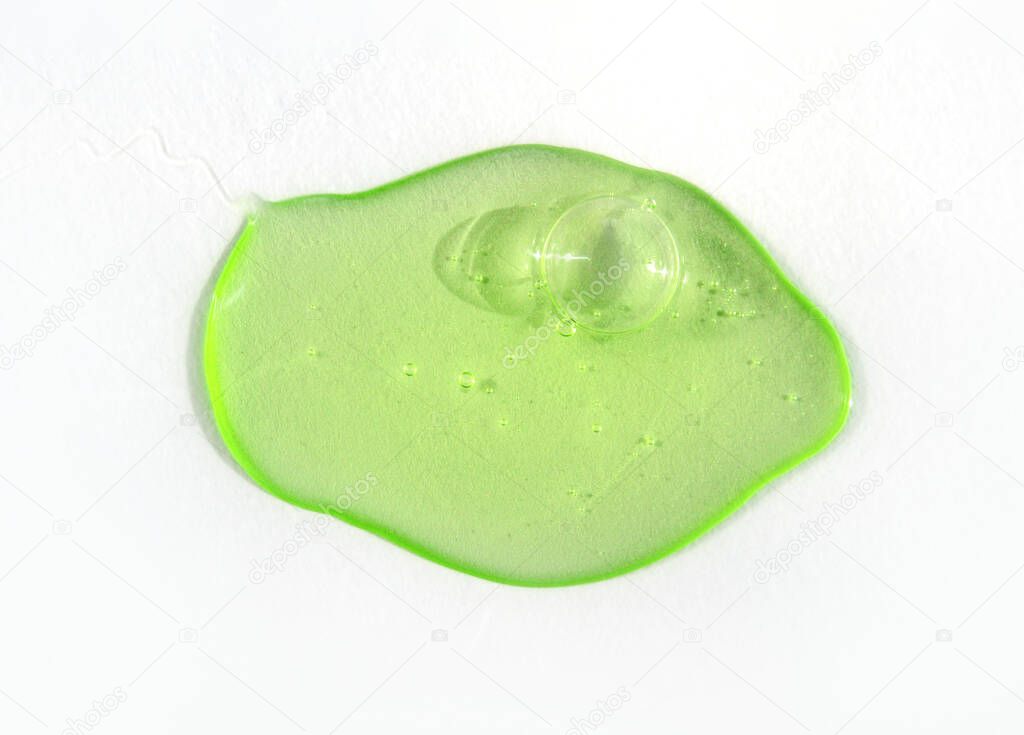 Drop of green fluid hyaluronic acid on white background. Cosmetics and healthcare concept closeup