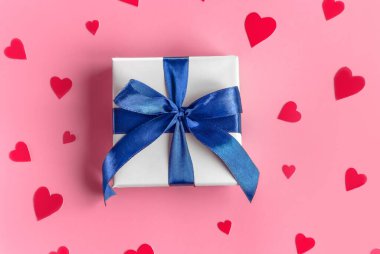 Pembe zemin üzerine beyaz ambalaj kağıdı ve kırmızı mor kalpler.