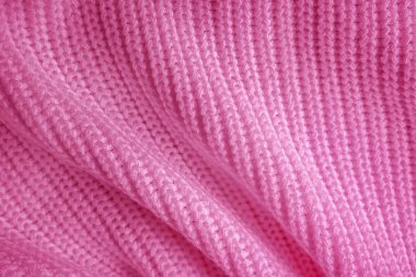 Yumuşak örülmüş süveter dokusu yakından. Soyut pembe arkaplan