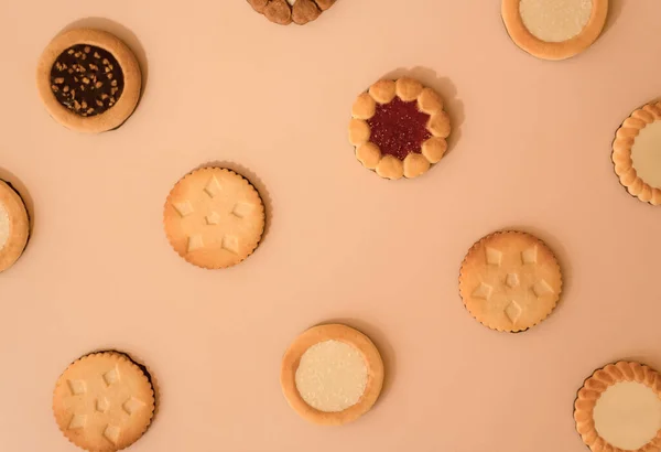 Différents modèles de biscuits à la fraise, à la noix de coco et au chocolat. Biscuits cuits au four isolés sur fond beige — Photo