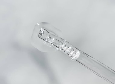 Tek renkli gri arka planda sıvı hyaluronik asit bulunan bir boru. Kozmetik ve sağlık konsepti yakın plan