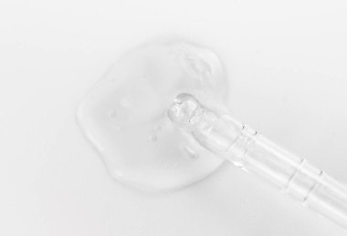 Tek renkli gri arka planda sıvı hyaluronik asit bulunan bir boru. Kozmetik ve sağlık konsepti yakın plan