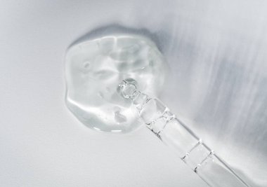 Tek renkli gri arka planda sıvı hyaluronik asit bulunan bir boru. Kozmetik ve sağlık konsepti yakın plan