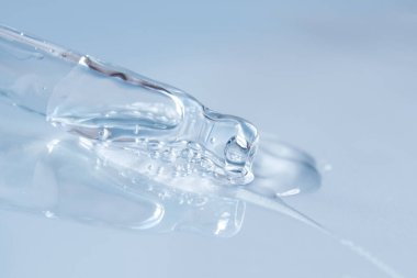 Tek renkli mavi arka planda sıvı hyaluronik asit olan bir boru. Kozmetik ve sağlık konsepti yakın plan