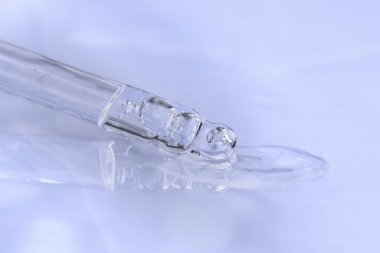 Tek renkli mavi arka planda sıvı hyaluronik asit olan bir boru. Kozmetik ve sağlık konsepti yakın plan