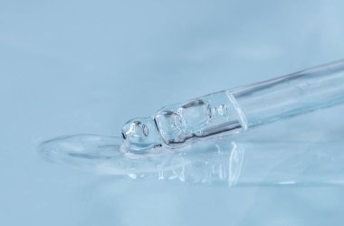 Tek renkli mavi arka planda sıvı hyaluronik asit olan bir boru. Kozmetik ve sağlık konsepti yakın plan
