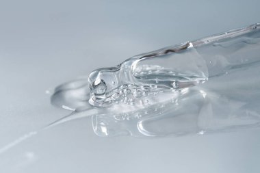 Tek renkli mavi arka planda sıvı hyaluronik asit olan bir boru. Kozmetik ve sağlık konsepti yakın plan