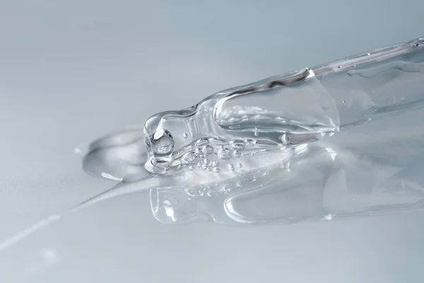 Tek renkli mavi arka planda sıvı hyaluronik asit olan bir boru. Kozmetik ve sağlık konsepti yakın plan