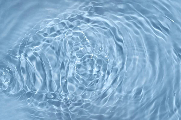 水の上の円。青い丸の影。モノクロームで水と光で作られた背景がぼやけています。. ストック写真
