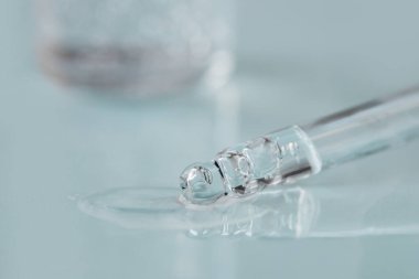 Tek renkli mavi arka planda sıvı hyaluronik asit olan bir boru. Kozmetik ve sağlık konsepti yakın plan