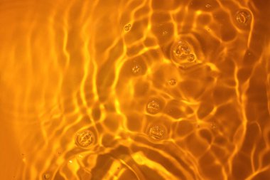 Sudaki dairelerin dokusu. Turuncu arkaplanda sıvı damlaları