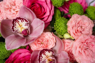 Parlak pembe çiçek buketi yakın plan. Güller ve orkideler duvar kağıdı. Bir doğum günü için güzel arkaplan