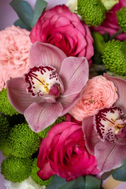 Parlak pembe çiçek buketi yakın plan. Güller ve orkideler duvar kağıdı. Bir doğum günü için güzel arkaplan