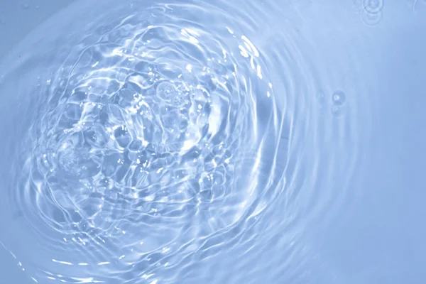 Círculos en el agua. Sombras redondas azules. Fondo borroso hecho con agua y luz en monocromo. — Foto de Stock