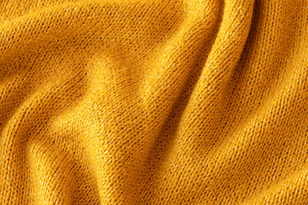 柔らかいニットイエローセーターの質感を閉じます。ライトオレンジの抽象的な背景 — ストック写真