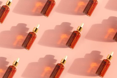 Şeffaf kehribar rengi cam damlalar. İçinde sıvı var. Bej arka planda.