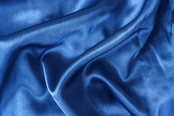 Elegante Nahaufnahme aus glatter blauer Seide oder Satin. Stoff Textur Hintergrund. Abstrakte Tapete — Stockfoto