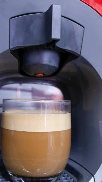 coffee with milk in crystal glass in the coffee maker