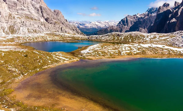 İlk kar yağdığında Dolomitler, İtalya 'da Drei Zinnen veya Tre Cime di Lavaredo yakınlarındaki Laghi dei Piani adlı iki dağ manzaralı.
