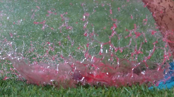 Een Rode Bal Gevuld Met Water Afgeplat Door Trap Van — Stockfoto