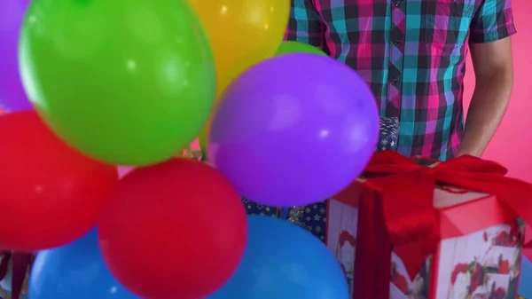 五彩缤纷的气球紧靠着一个绑着红丝带的节日礼盒 — 图库照片