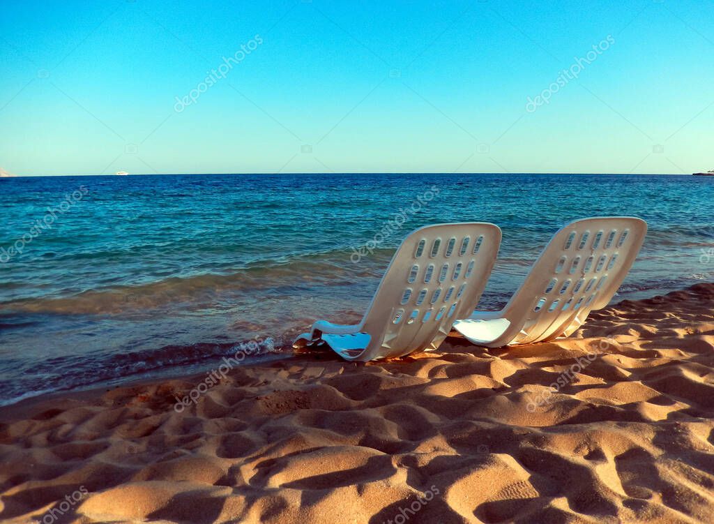 two beach chairs by the sea. concept of rest and relaxation. Armchairs on the sandy beach next