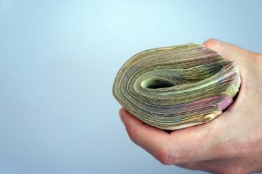 human hand holds a stack of Ukrainian hryvnia banknotes on a light background. money and finance concept. financial background