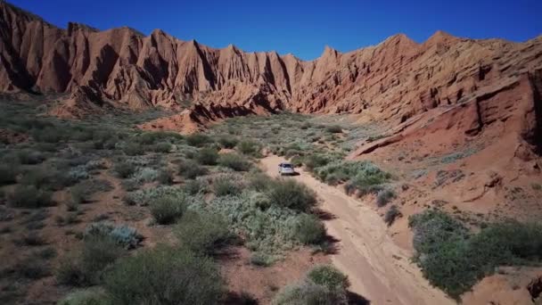 Ένα Αυτοκίνητο Που Οδηγεί Βαθύτερα Στο Offroad Και Κόκκινα Βουνά — Αρχείο Βίντεο