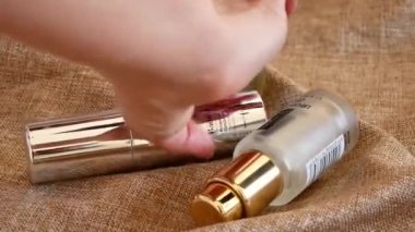 Bir çift flakon sunuluyor ve bir kadın eli bir tanesini seçiyor.