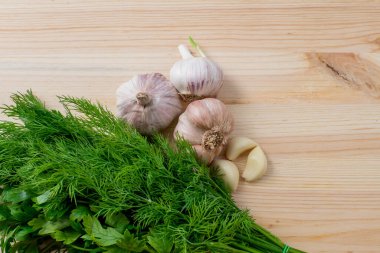 Garlic and herbs on wooden background. Top view, copy space.