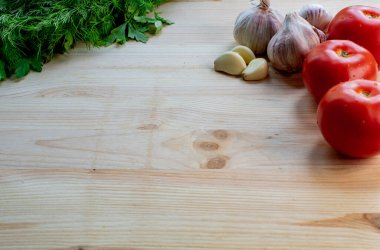 Cooking fresh ingredients background. Organic tomatoes, garlic and herbs on wooden background, top view, copy space.