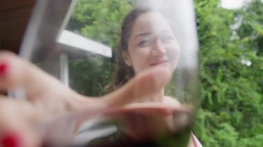 Güzel pembe elbiseli, geniş yakalı melez bir kız bardağını tokuşturup kameraya bakarken gülümsüyor. Düğündeki Asyalı kadın kadehleri tokuşturup bardaktan kırmızı şarap içiyor...