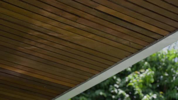 Primo piano di un bellissimo tetto in legno su cui si muovono i raggi del sole del riflesso del sole dalla superficie dell'acqua della piscina. Soli giochi di abbagliamento sul tetto moderno sullo sfondo di — Video Stock