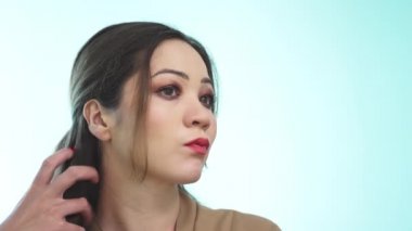 Parlak makyajlı ve uzun siyah saçlı güzel bir kız aynaya bakar ve saç stilini düzeltir. Asyalı bir kız aynaya bakıp yüzünü içeride muayene ediyor. Yavaş çekim.