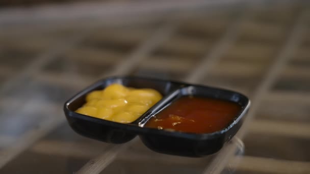 Gros plan d'une personne trempant un tacos mexicain dans un bol de sauce au fromage et ramassant la sauce. Typique de manger des plats mexicains épicés. Il y a un bol de ketchup rouge et une sauce au fromage collante. — Video