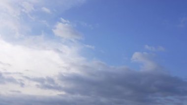 Mavi gökyüzü ve hareket eden beyaz bulutların zaman aralığı. Beyaz bulutların dokuları mavi gökyüzü arka planına karşı şekilleniyor. Güzel gün batımı zamanı. Atmosferdeki büyüleyici bulut oluşumu