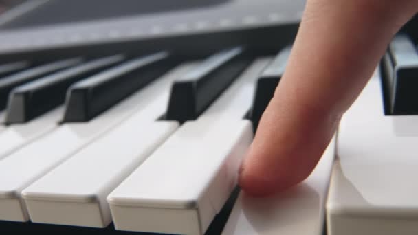 El pianista pasa su dedo sobre las teclas blancas del piano. La persona pasa el dedo sobre las teclas del sintetizador electrónico. Macro plan de acompañamiento de dedo jugando en las teclas. En cámara lenta. Primer plano. — Vídeo de stock