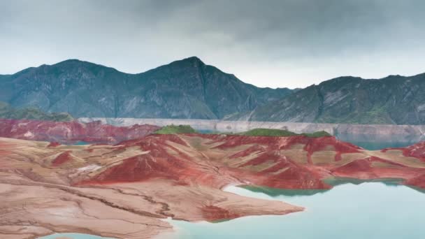 Landschaft, die entlang des Flusses mit türkisfarbenem Wasser und roten Sandstränden vor dem Hintergrund felsiger Berge fliegt. Aufgrund der globalen Erwärmung hat sich der Wasserspiegel verändert, eine alte Wasserlinie ist auf den Felsen sichtbar — Stockvideo