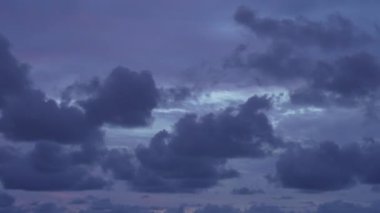 Gece mavisi gökyüzünün gökyüzünde süzülen mor bulutlar, uçan uçakların parlak ışıkları. Alacakaranlıktan geceye geçen ilahi bir manzara. Hızlı hareket eden kara bulutlar.