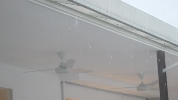 Roof of a white modern cafe with raindrops dripping on background of the fans turned off. Part of the interior of an outdoor summer cafe during a heavy torrential downpour. Rainy weather. Slow motion — Vídeo de Stock