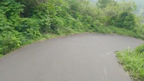Pov of a man walking on a motorcycle on a mountain slope and after turning, lost control himself, falls off the motorcycle. A man lost control and falls off a scooter on a mountain paved road. — Vídeo de Stock