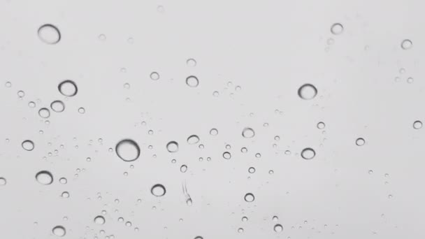 Macro disparo de una superficie transparente vibrando de las gotas de agua que caen sobre él. La superficie transparente del paraguas y las gotas de lluvia que caen sobre él. Abstracto. superficie 4k. — Vídeo de stock