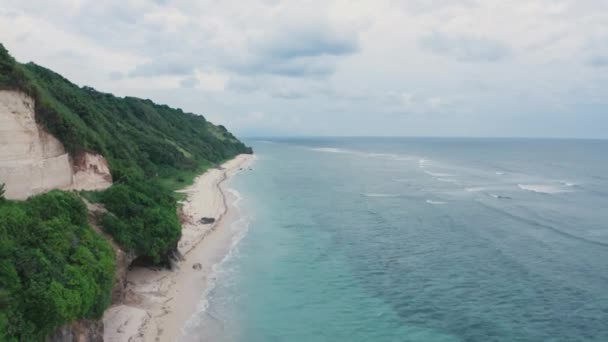 Filmagem aérea da bela paisagem oceânica com árvores verdes, rochas, praia e água azul transparente com recife. Paraíso tropical à beira-mar. Drone tiro de praia de areia branca com água clara azul. — Vídeo de Stock