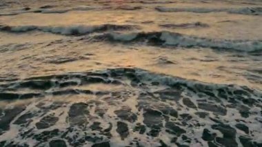 Batan güneşin ışınlarıyla karanlık okyanus dalgaları üzerinde uçmak. Akşamları fırtınadan önce dalgalı bir denizi olan endişe verici bir karanlık çerçeve. Yaz zamanı. Karanlık okyanus suyunun dokusu.