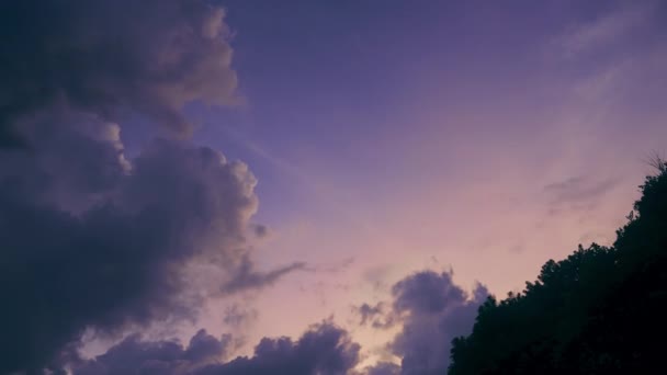 Un hermoso timelapse con un cielo púrpura puesta de sol y nubes flotantes con una luz naranja brillante de puesta de sol. Una pintoresca puesta de sol brillante en disparo acelerado con un hermoso cielo rojo brillante. — Vídeos de Stock